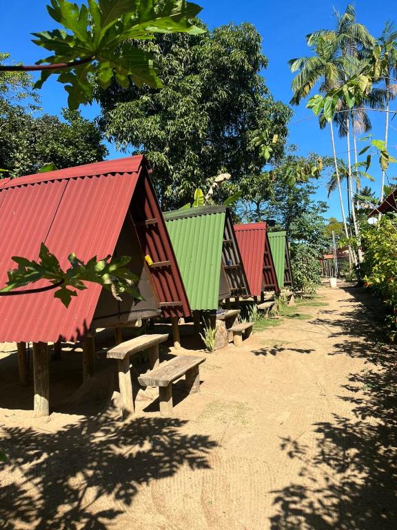 a row of colorful huts sitting on the beach at Cabana 2 Camping Dona Aurora Praia do Sono in Paraty