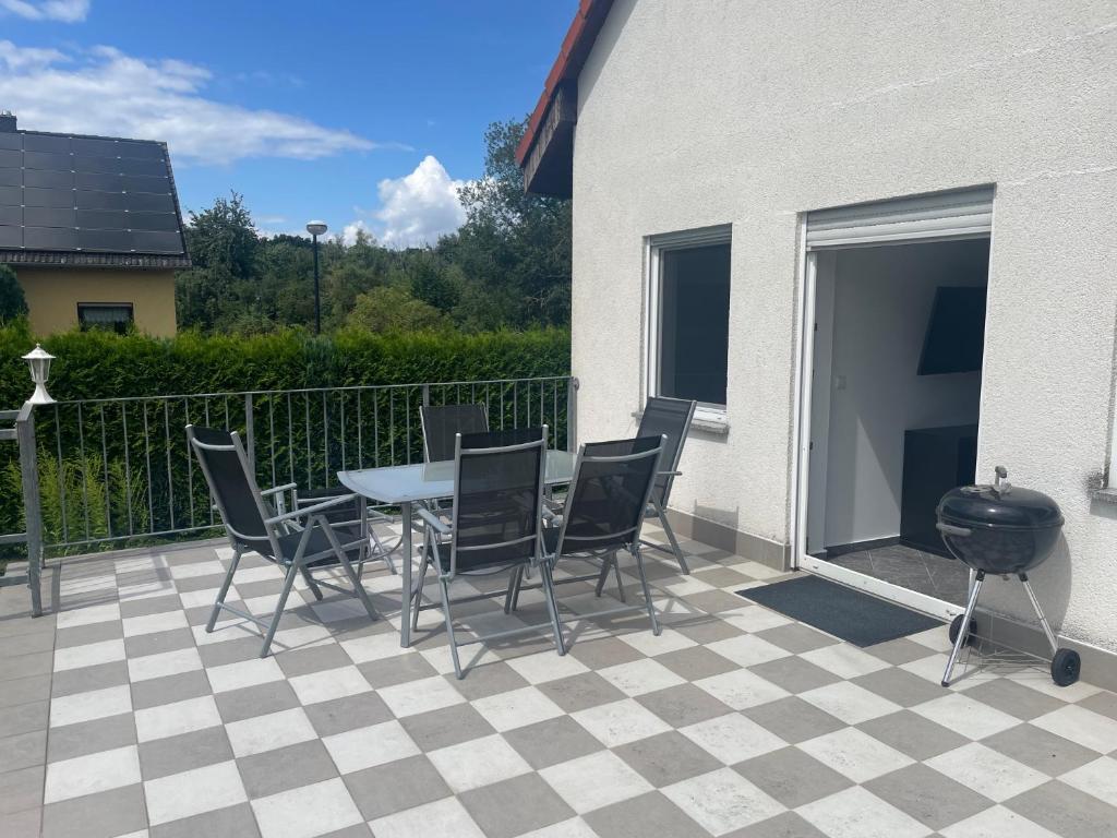a patio with a table and chairs and a grill at Eastside - Apartment WHG 02 in Senftenberg