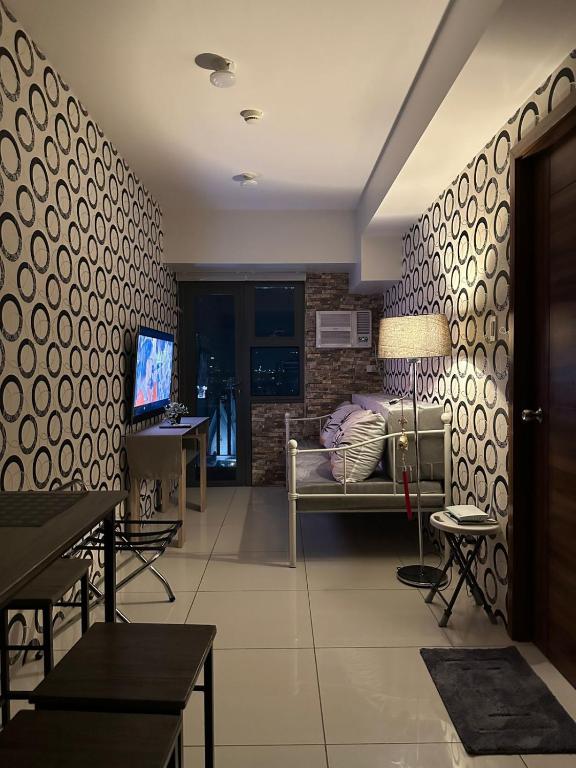 a living room with a couch and a television at The Monroe at Horizons 101 in Cebu City