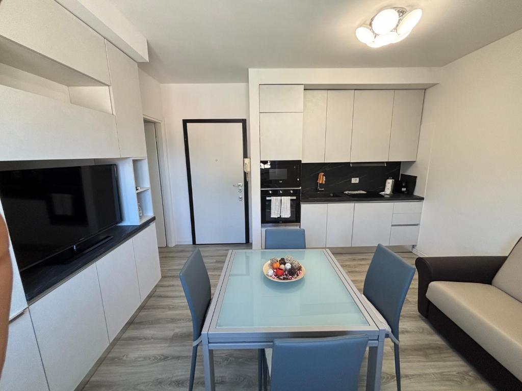 Una cocina y una sala de estar con una mesa y un sofá. en Lecco Deluxe Apartment, en Lecco