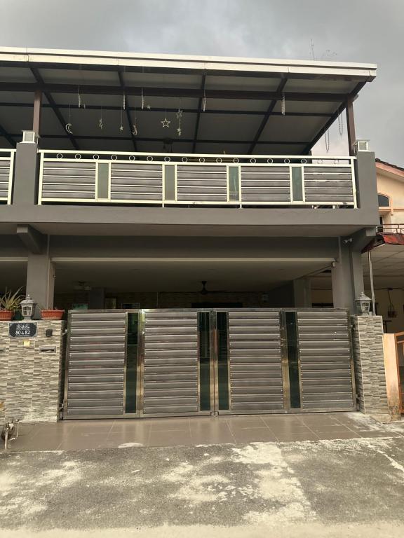 a large house with a gate and a balcony at MM HomeStay 82 in Kamunting