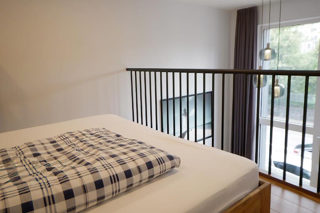 a bed with a plaid blanket on it next to a window at KgB - 32, Stylish City Apartment - 10 mins walk to Old Town in Vilnius