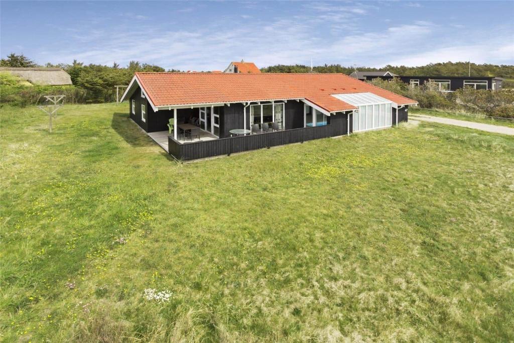 una casa con techo rojo en un campo de césped en 970-Thisted-Klitstien-47, en Torsted