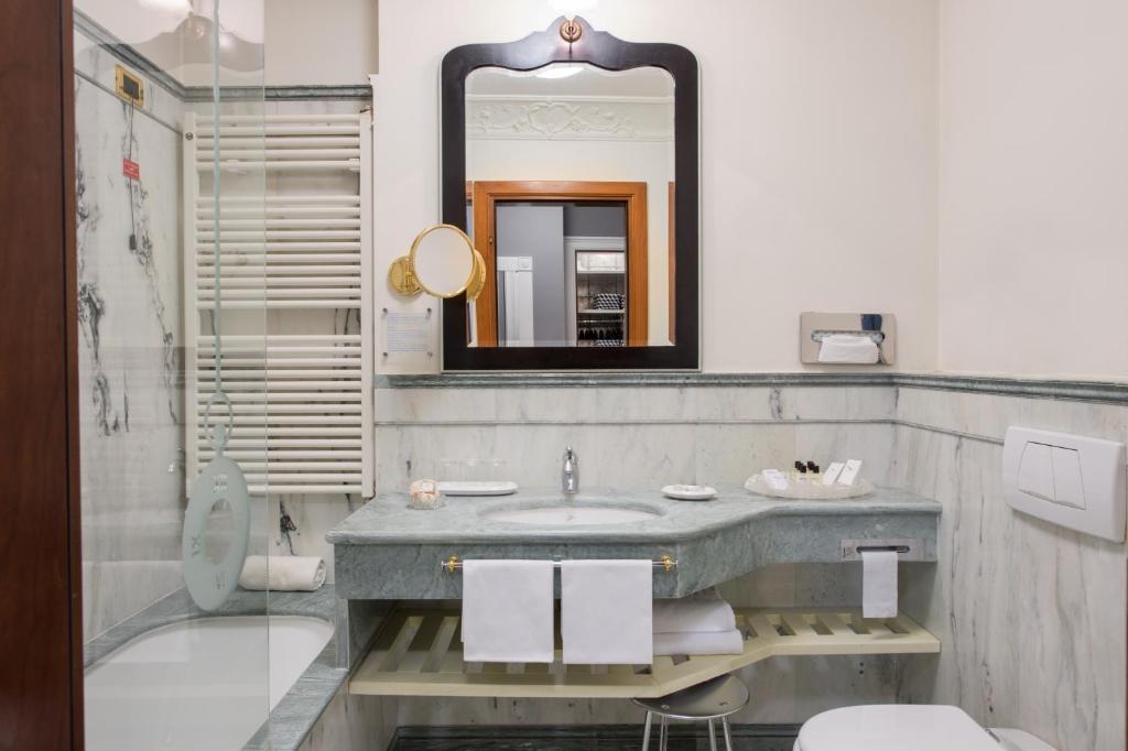a bathroom with a sink and a mirror at Art Hotel Orologio in Bologna