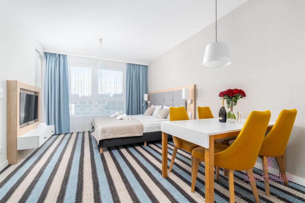Una habitación de hotel con una cama, una mesa y sillas. en Your Holidays Bel Mare 402D, en Międzyzdroje