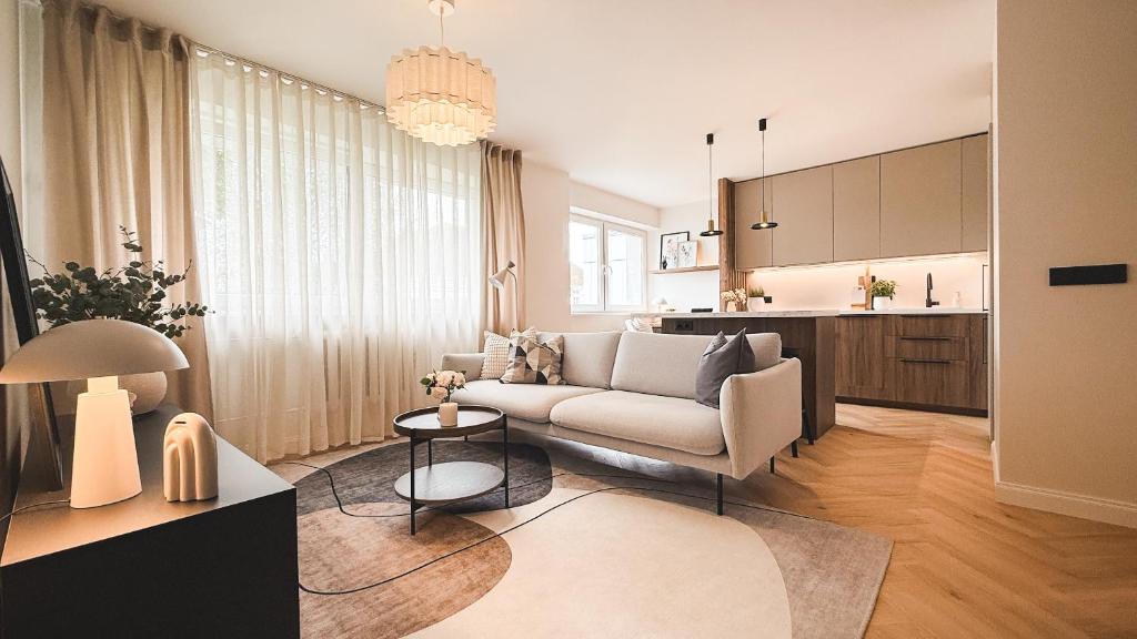 a living room with a couch and a kitchen at Riia street apartment with parking in Tartu