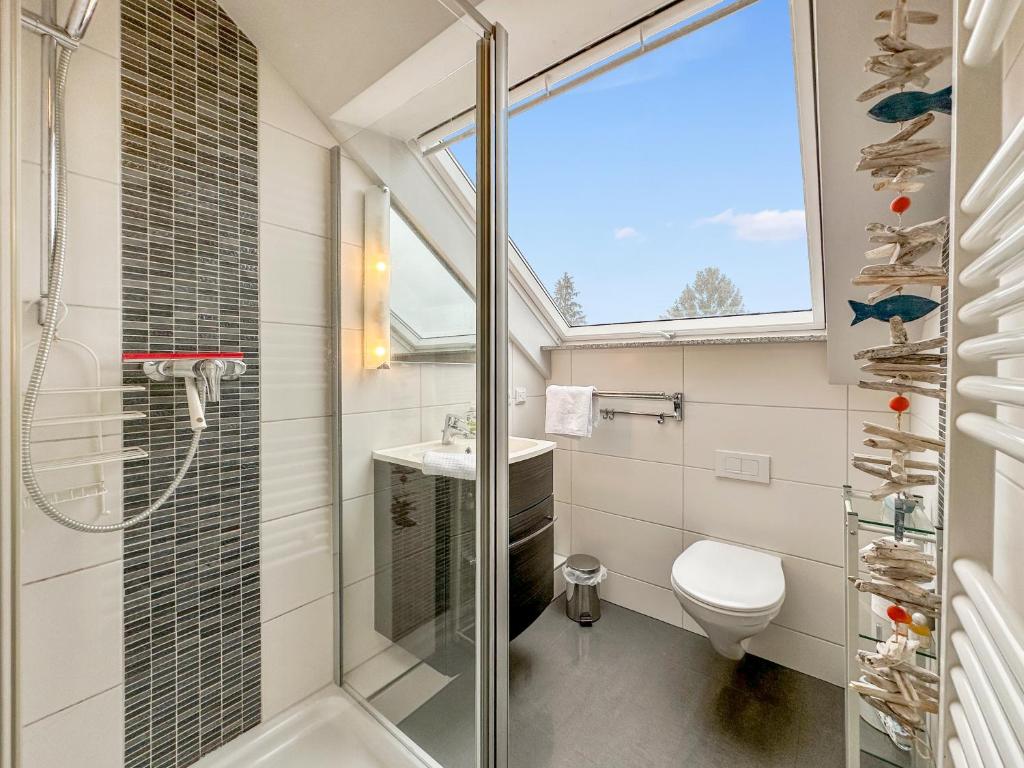 a bathroom with a shower and a toilet and a sink at FeWo Rose 52 Travemünde in Travemünde