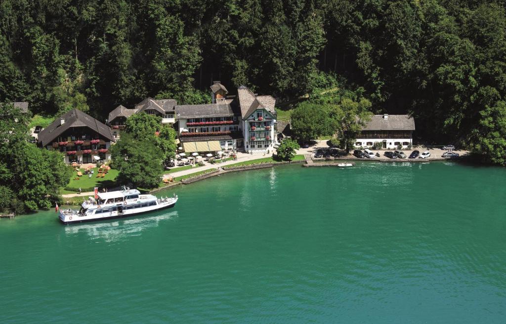 a boat in the water in front of a resort at Hotel & Gasthof Fürberg in Sankt Gilgen