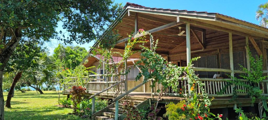 a wooden house with a porch and a balcony at Cliffside Amani Wooden Villa with Stunning Ocean Views for an Authentic Tanzanian Escape in Dar es Salaam