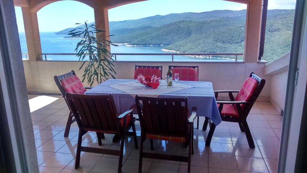 a table and chairs on a balcony with a view at Apartments Silmare in Rabac