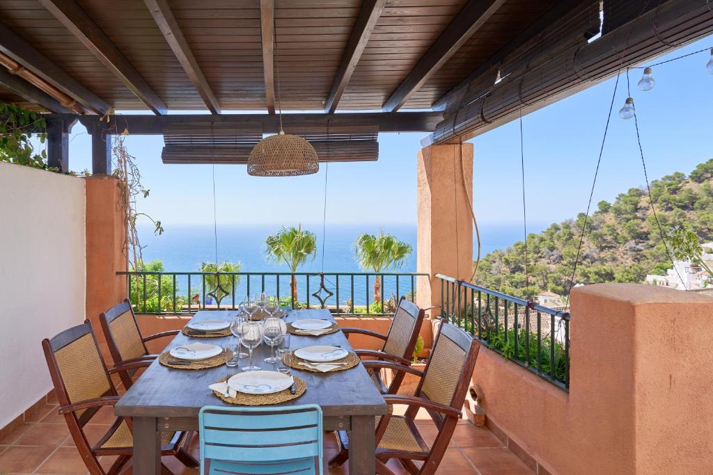 a table on a balcony with a view of the ocean at Stunning sea views pool garden in La Herradura