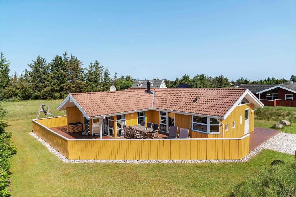 a large yellow house with a deck in a field at 233-Thisted-Tunvej-5 in Thisted