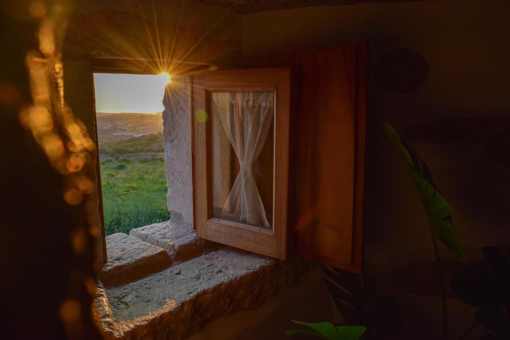 an open window with a view of a field at Moinho das Longas in Montelavar