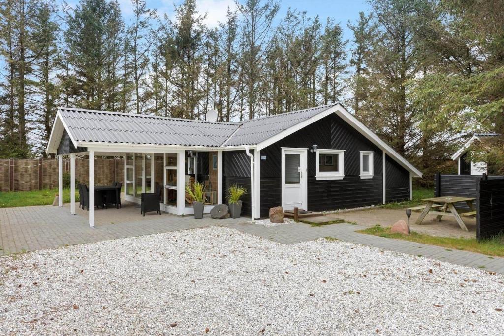 a black house with a patio and a picnic table at 862-Thisted-Nordsovej-162 in Thisted