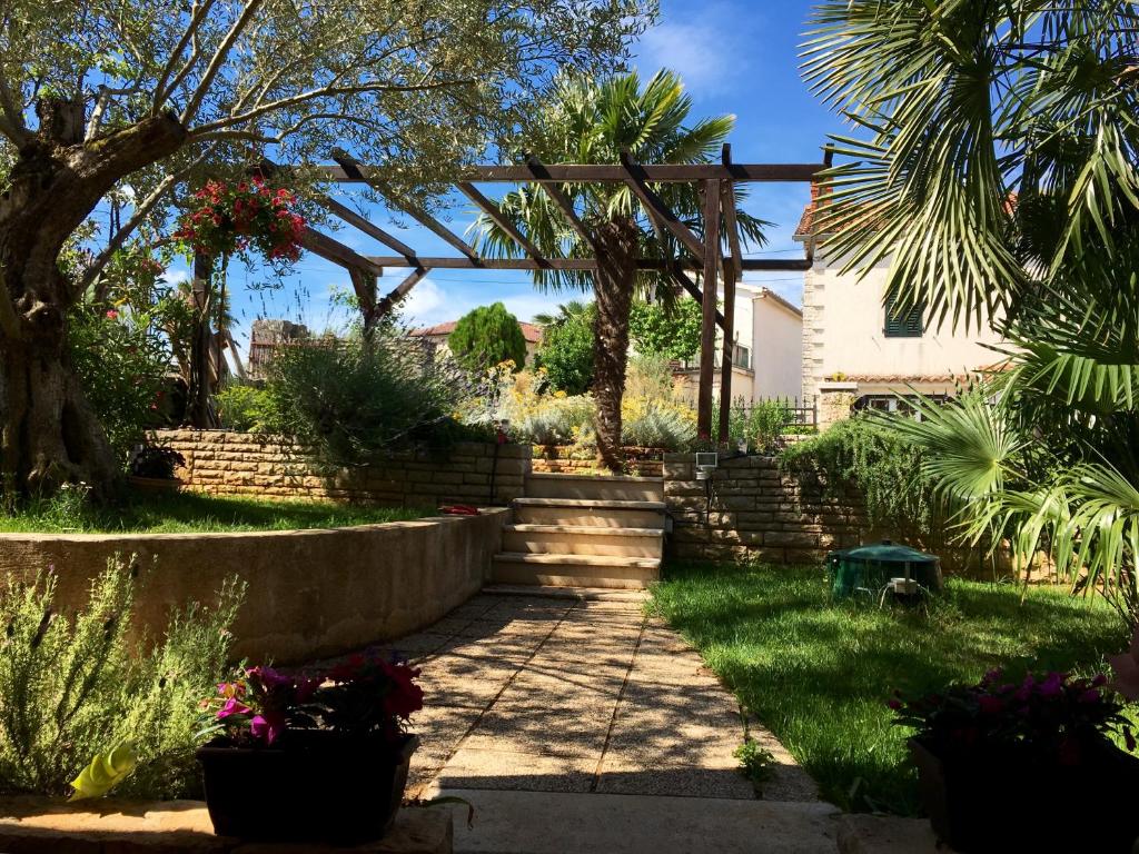 a garden with a stone path and a pergola at Juli's Place in Rovinjsko Selo