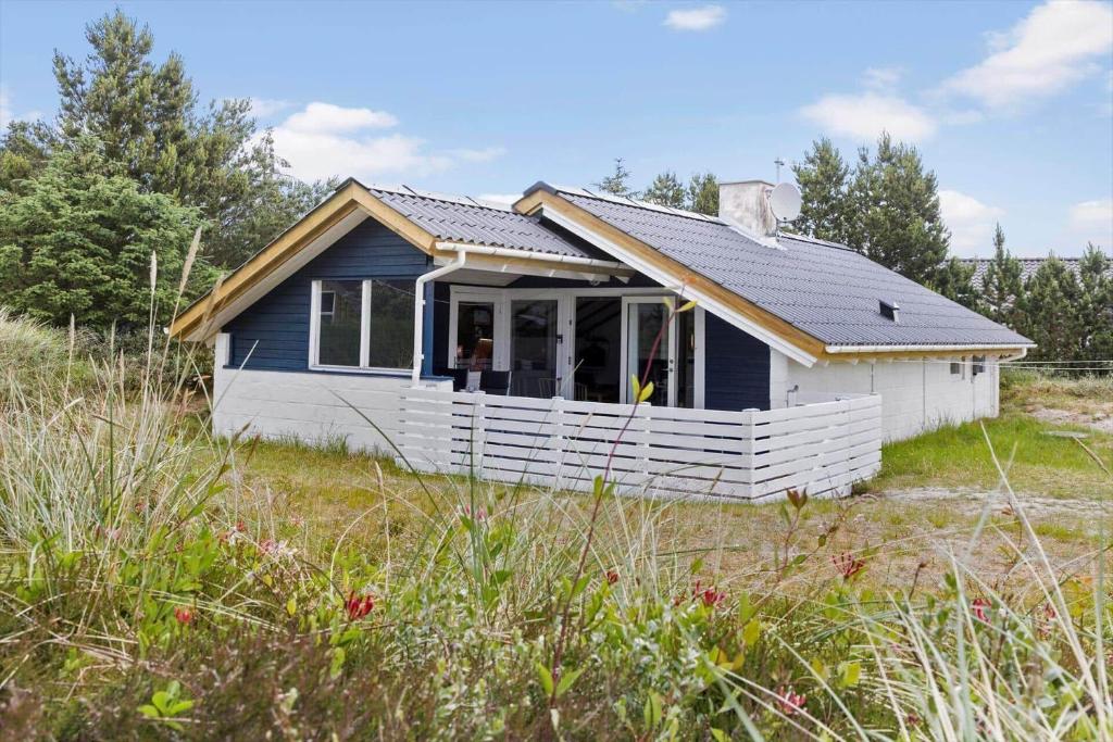 a small blue and white house in a field at 692-Thisted-Mose-Bollevej-6 in Thisted