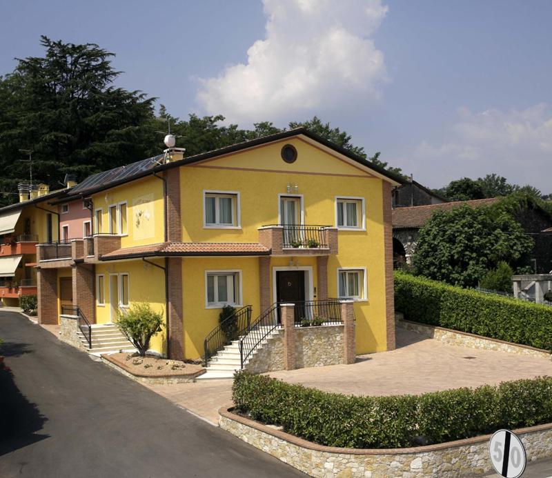 a yellow house with a driveway in front of it at Albergo Corte di Emma in Arzignano