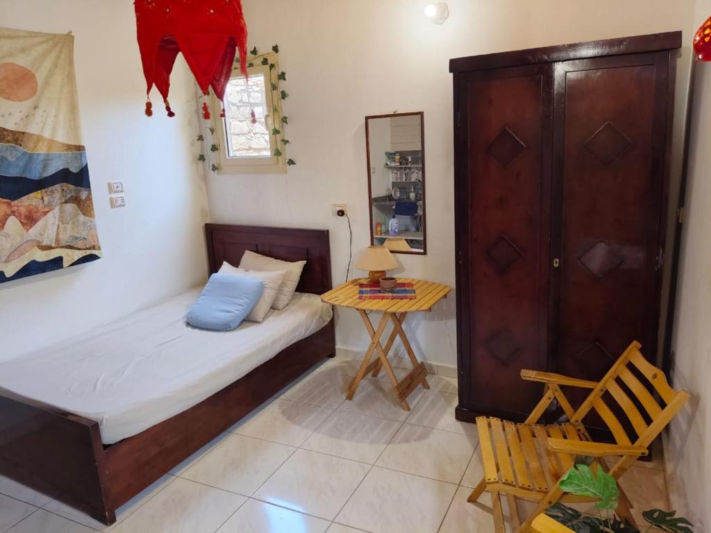 a small bedroom with a bed and a table at Light House studio in Dahab