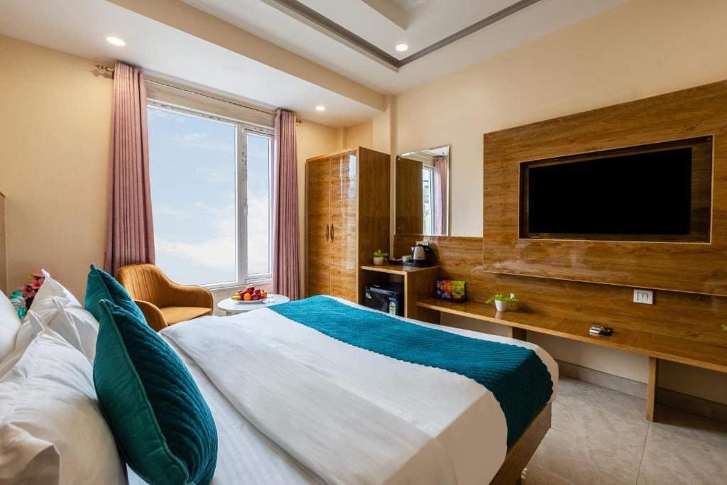 Un dormitorio con una cama grande y un televisor de pantalla plana. en Hotel Guru Preet - Near to New Delhi Railway Station & Connaught Place, en Nueva Delhi