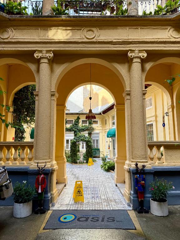 a building with a sign in the middle of a courtyard at Oasis Inn Budapest in Budapest