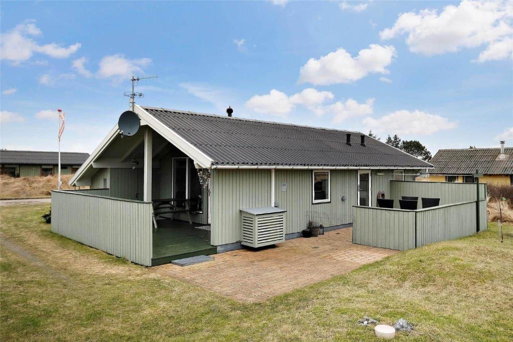 een klein groen huis met een patio in een tuin bij 802-Thisted-Pighvarvej-22 in Thisted
