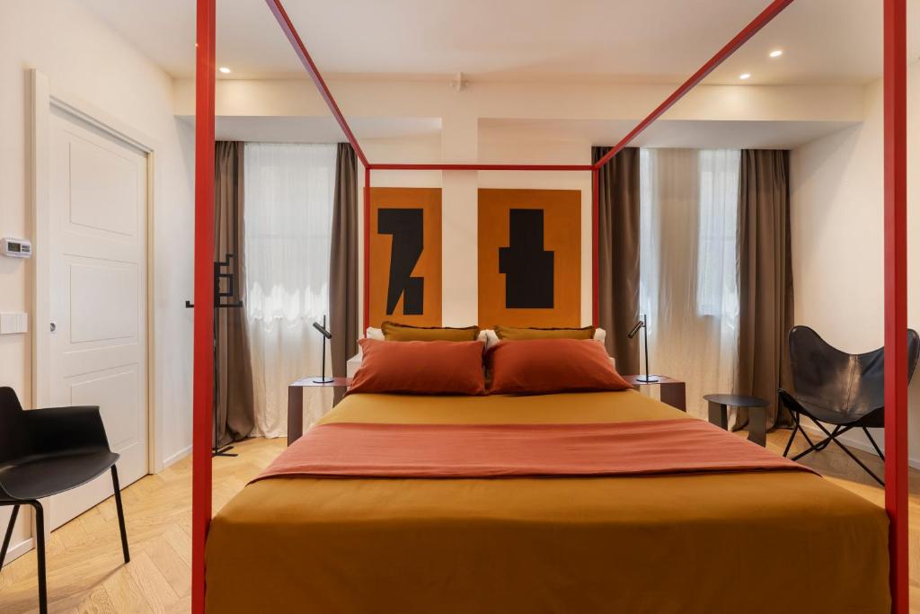 una camera da letto con un letto grande e due sedie di Fra le righe - arte , design e interni siciliani a Catania