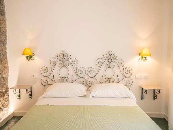 a white bed with two pillows in a bedroom at Le Roccette Club in Tropea
