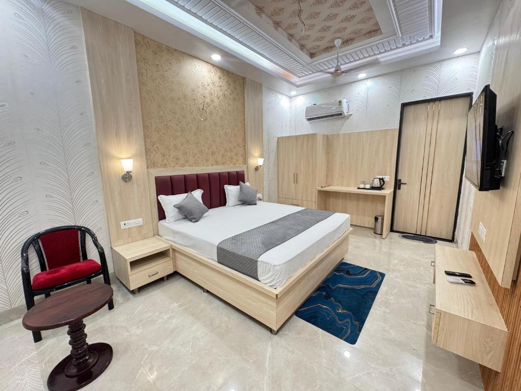 a bedroom with a bed and a red chair at KANHA RETREAT - Vrindavan in Vrindāvan