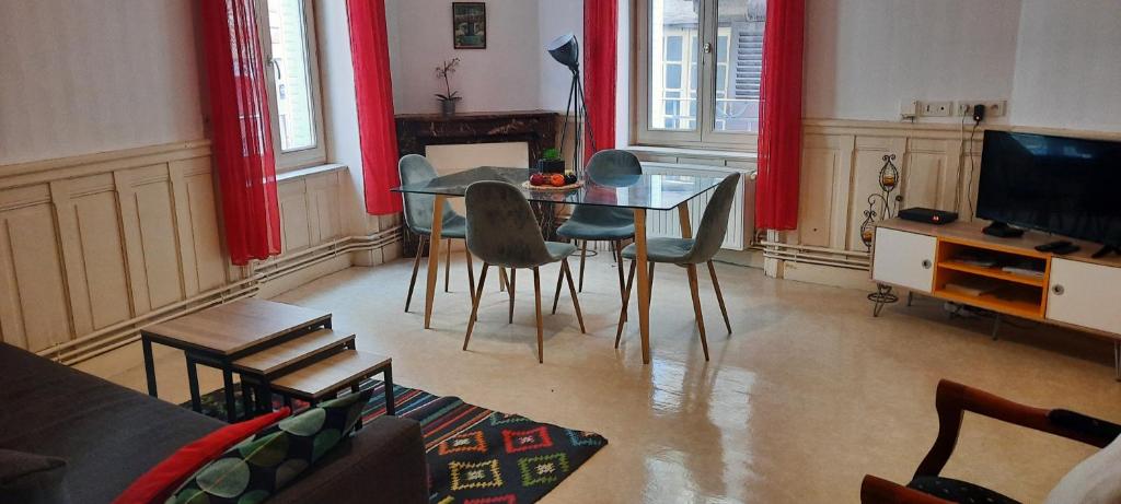 a living room with a glass table and chairs at Apparts Coeur Historique de Thiers - Tarifs dégressifs - Idéal PROS in Thiers