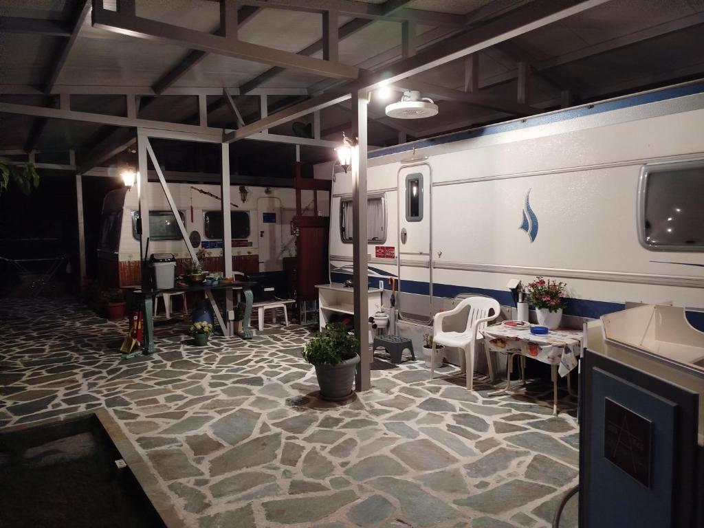ein Raum mit Stühlen und Tischen und einem Anhänger in der Unterkunft DamAnda mare in Nea Potidaea