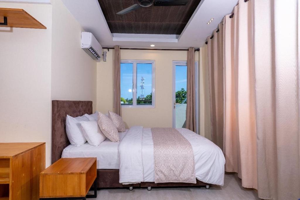 a bedroom with a bed and a large window at Fen Villa in Dharavandhoo