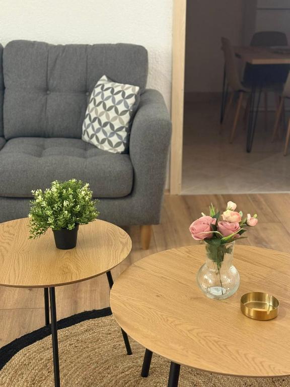 a living room with a couch and two tables with flowers at Villa Georgi in Ohrid