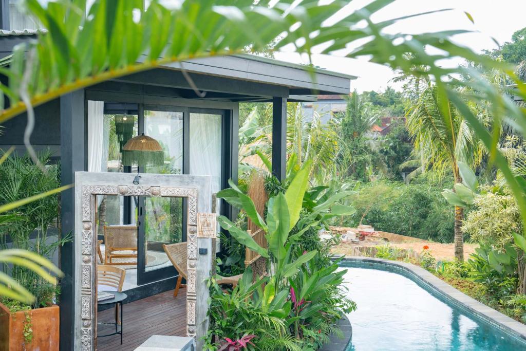 un miroir devant une maison avec piscine dans l'établissement Lorel Green Domain Ubud, à Ubud