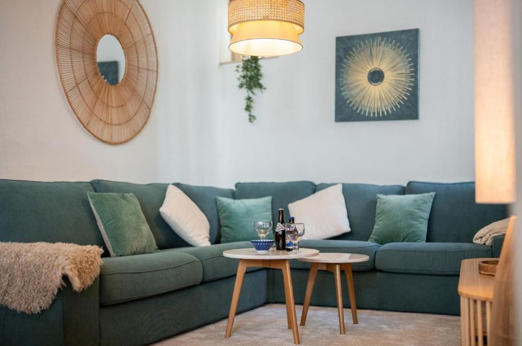 a living room with a blue couch and a table at La Maison Rouge de Givet in Givet