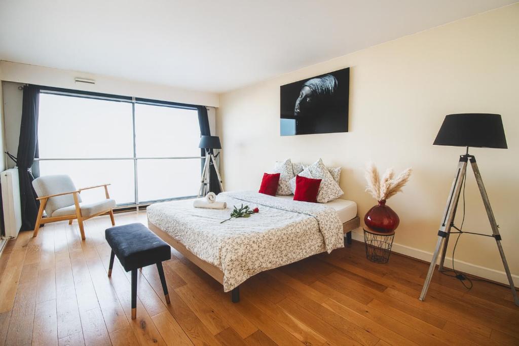 a bedroom with a bed with red pillows at Appartement spacieux vue Cathédrale in Reims