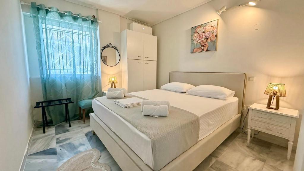 a white bedroom with a bed and a window at Free Spirit Nectar in Kalamata