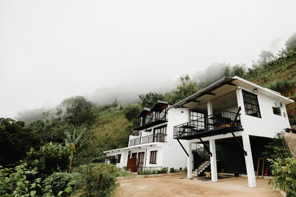 a house on a hill with fog in the background at O'Neill's Cottage in Dikkapitiya