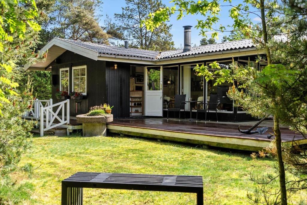 a small black house with a wooden deck at 1344-Vestervig-Hedevej-43 in Vestervig