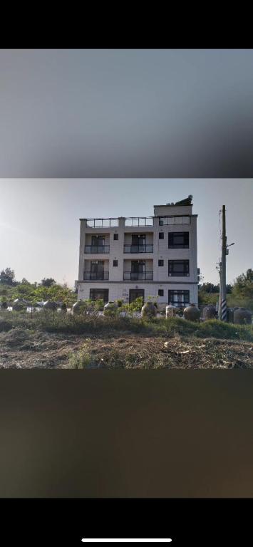 a large white building in front of a building at Shanhai B&B in Jinning