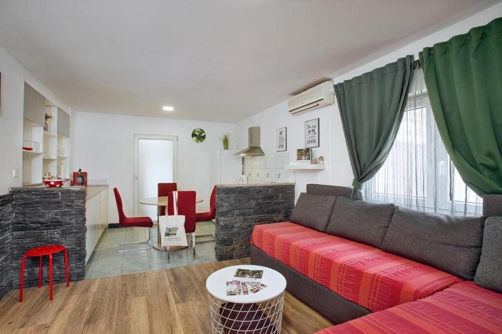 a living room with a red couch and a table at Kuća za odmor Sparta in Dugo Selo