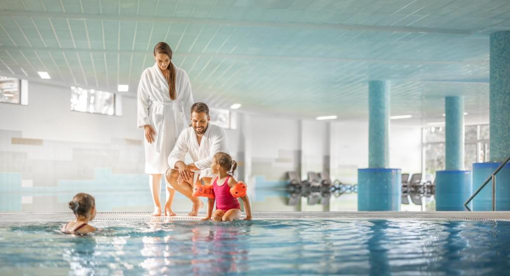 eine Familie spielt im Pool in der Unterkunft Remisens Hotel LUCIJA in Portorož