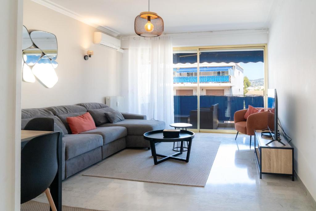 un salon avec un canapé et une table dans l'établissement Proche plages Parking Etage élevé Terrasse, à Antibes