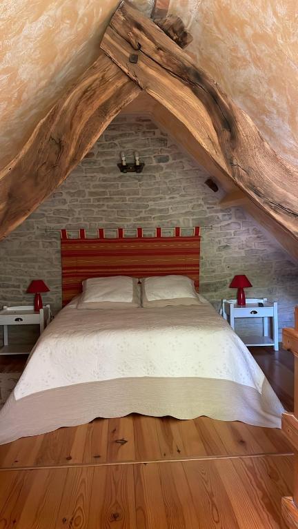une chambre avec un grand lit avec une tête de lit en bois dans l'établissement Mas d'Ambayrac chambres d'hôte Le four a pain, à Promilhanes