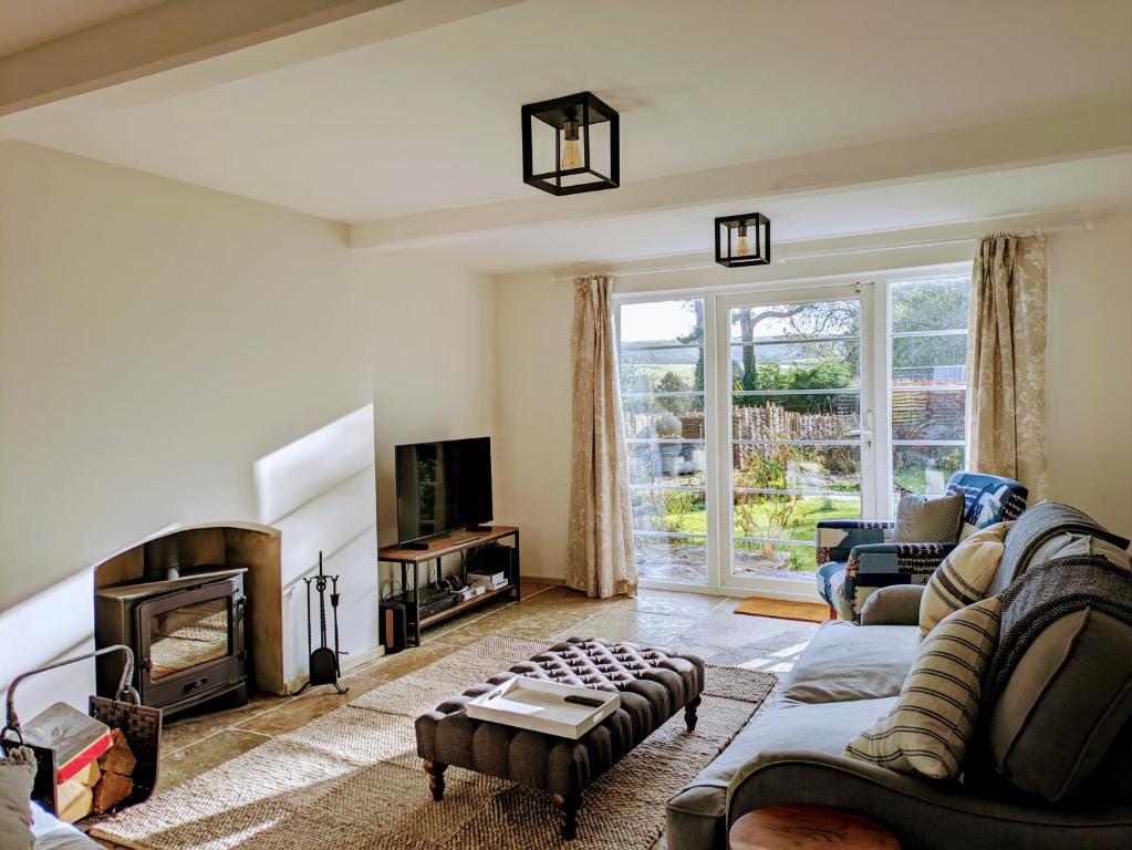 a living room with a couch and a fireplace at Fig Tree Cottage - Corfe Castle in Corfe Castle