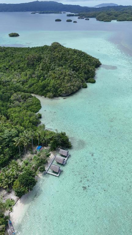 an aerial view of an island with chairs in the water at Maricho Homestay in Besir