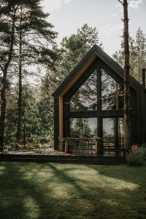 a cabin in the woods with a large window at Domek w Lesie in Rozogi