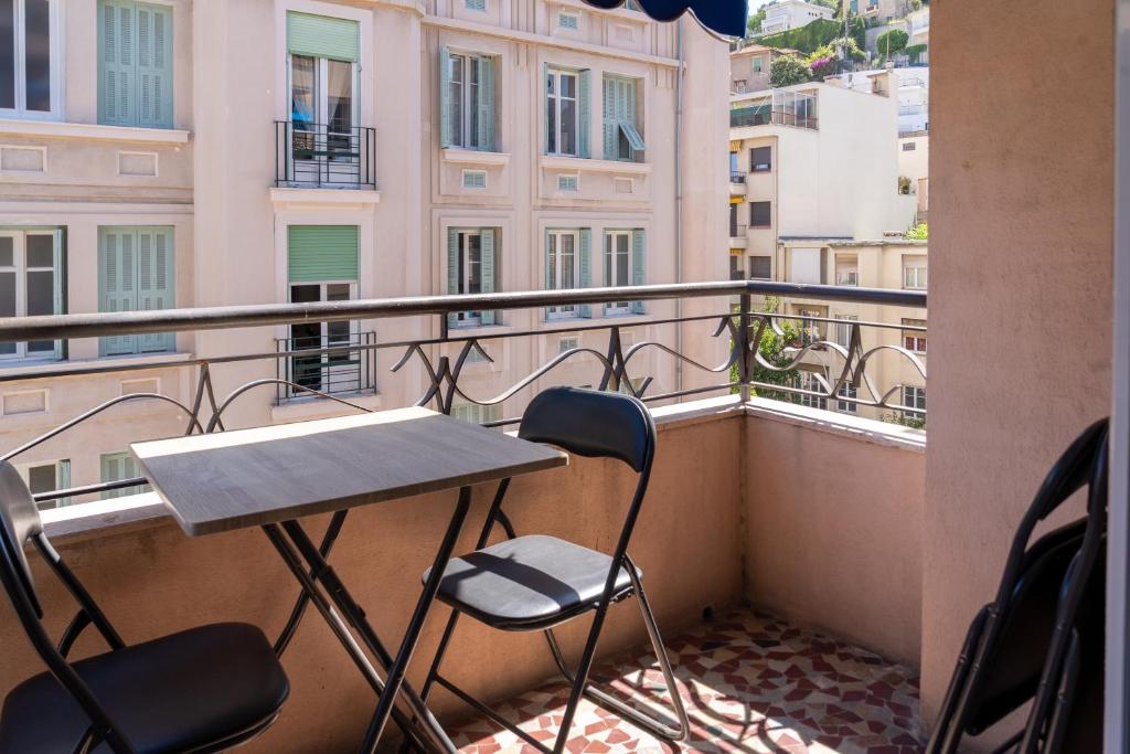 a balcony with a table and chairs on a balcony at 2 pièces - Clim - tram à 5' centre à 15' in Nice