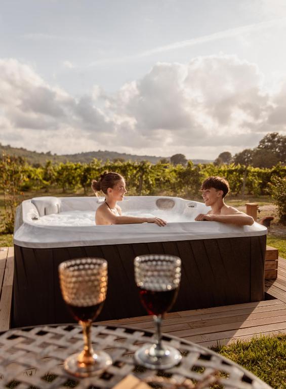 a man and a woman in a hot tub at Agriturismo La Vecchia Quercia in Montemerano