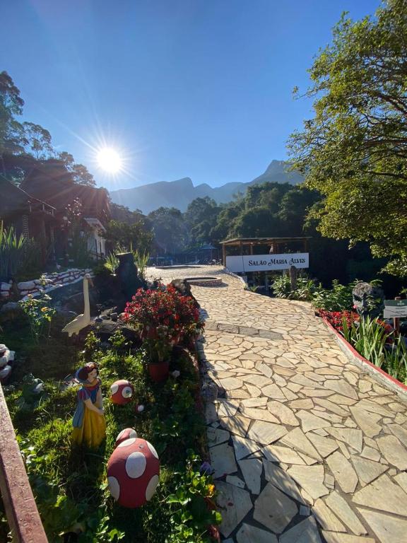a stone walkway with flowers in a garden at Pousada do Bezerra in Alto Caparao