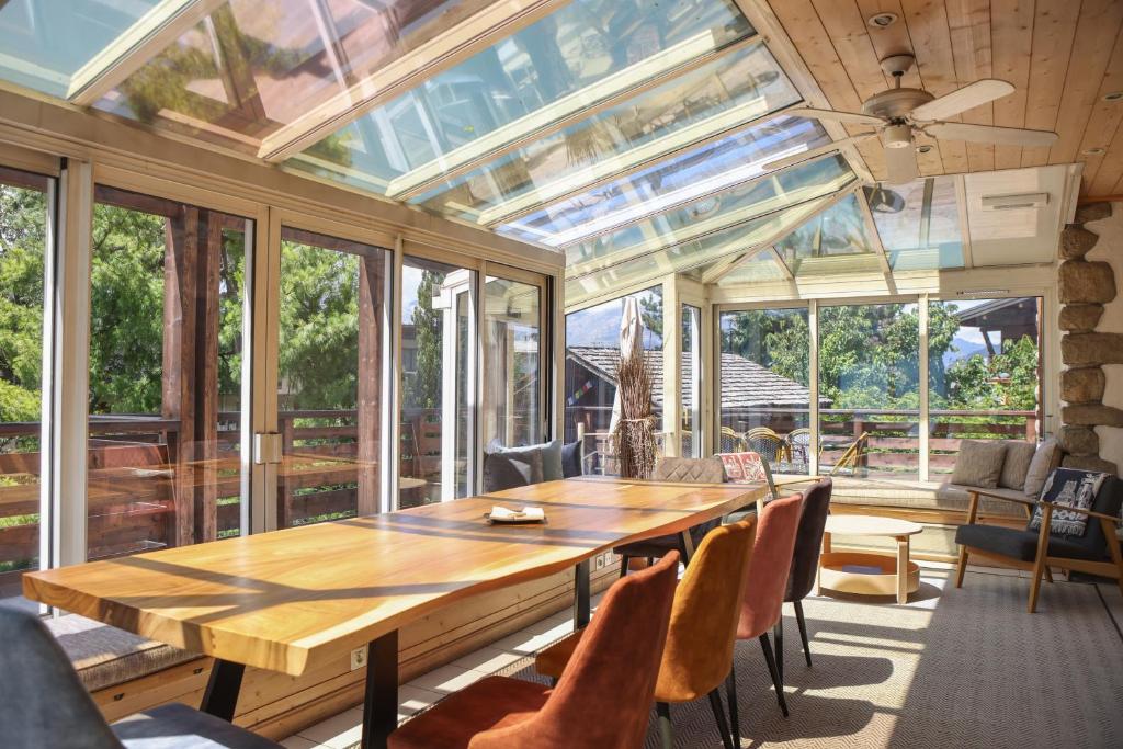 oranżerią z drewnianym stołem i krzesłami w obiekcie Chalet Belle-Sofianna w mieście Saint-Gervais-les-Bains